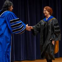 President shaking hands with female faculty